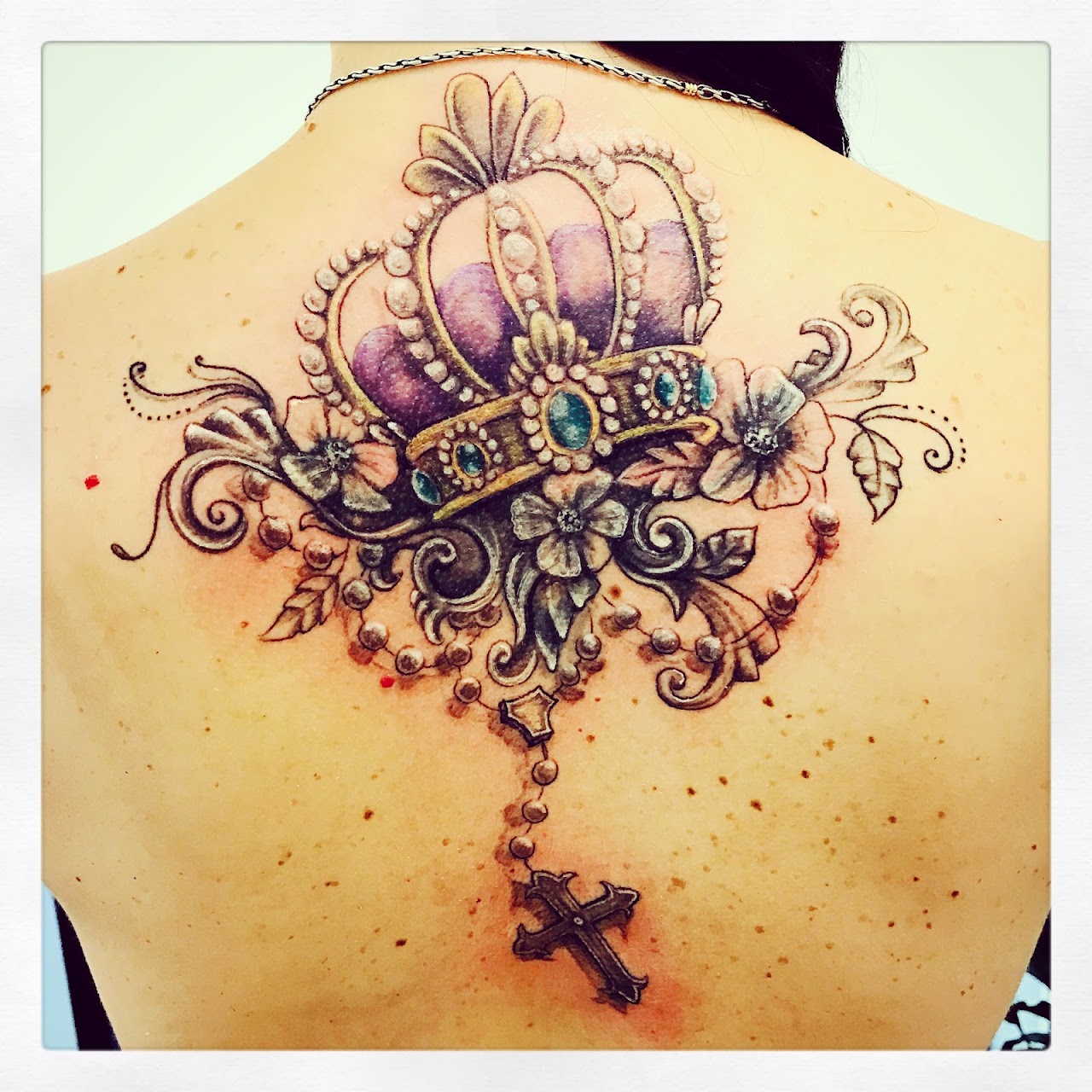 Tatuaje de corona y rosario en color y realismo, trabajo real del estudio